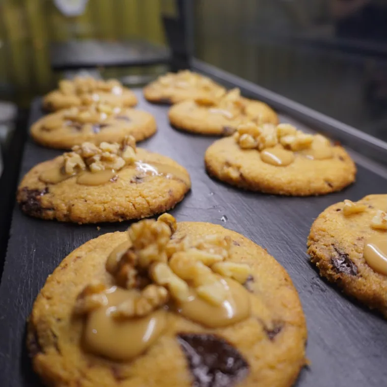 Cookies con nueces, caramelo y chocolate sobre pizarra