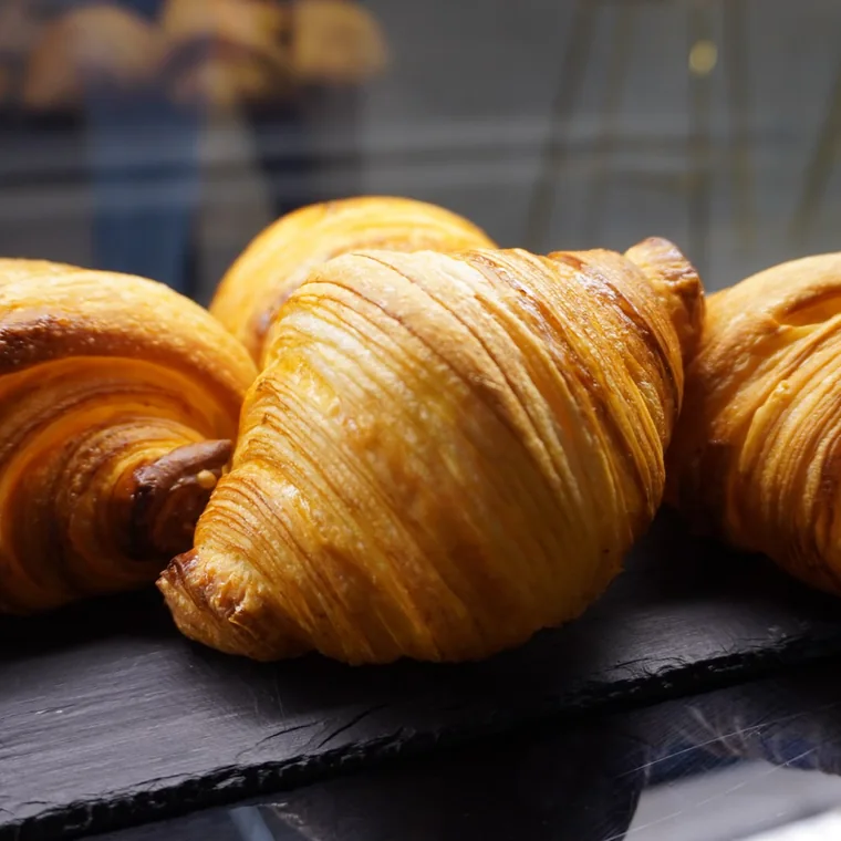 Croissant liso recién horneado sobre pizarra