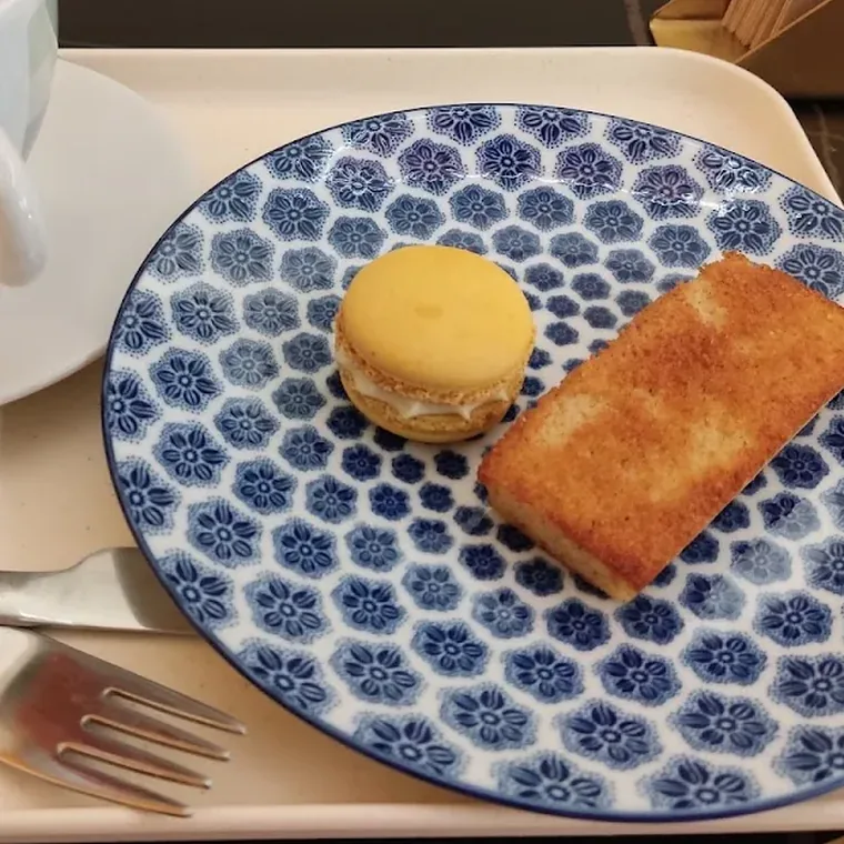 Financier de almendra en plato azul junto a un macaron