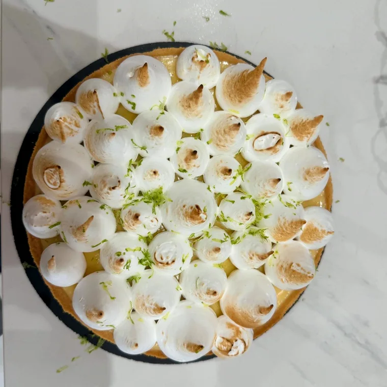 Tarta de limón cubierta de merengue tostado y ralladura de lima