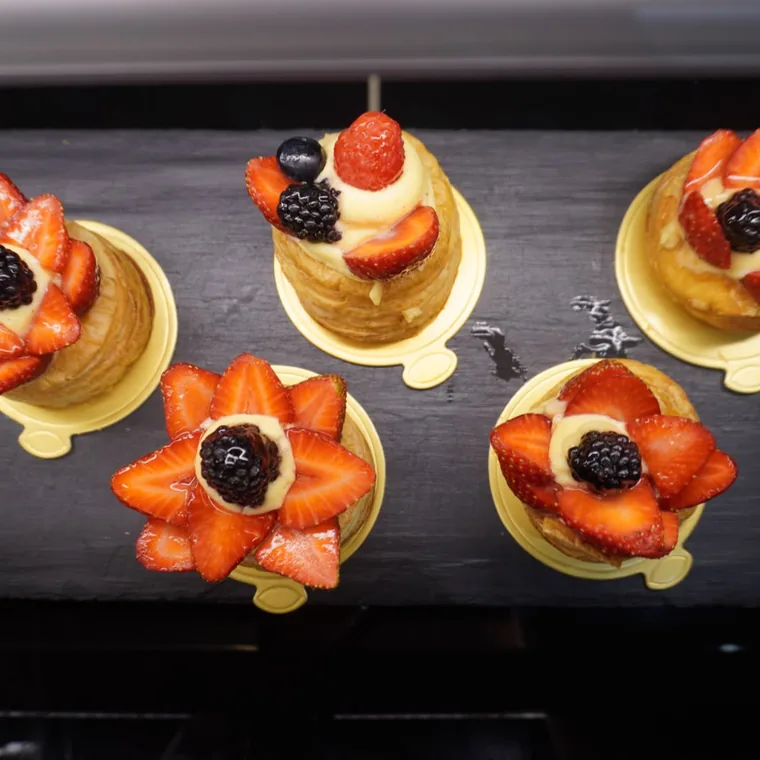 Tartaletas de hojaldre con crema y fresas abiertas en flor