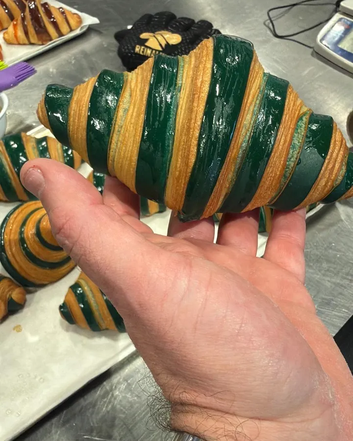 Croissant bicolor verde sostenido en la mano